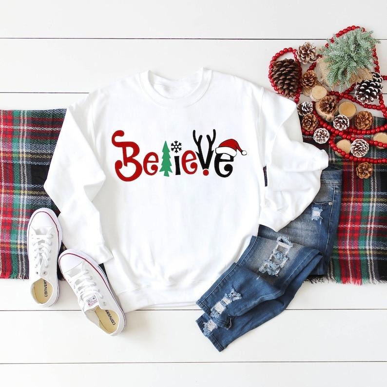 Believe Christmas Shirt - Long Sleeve Cotton T-Shirt with "Believe" Graphic, Ideal for Christmas Parties and Family...