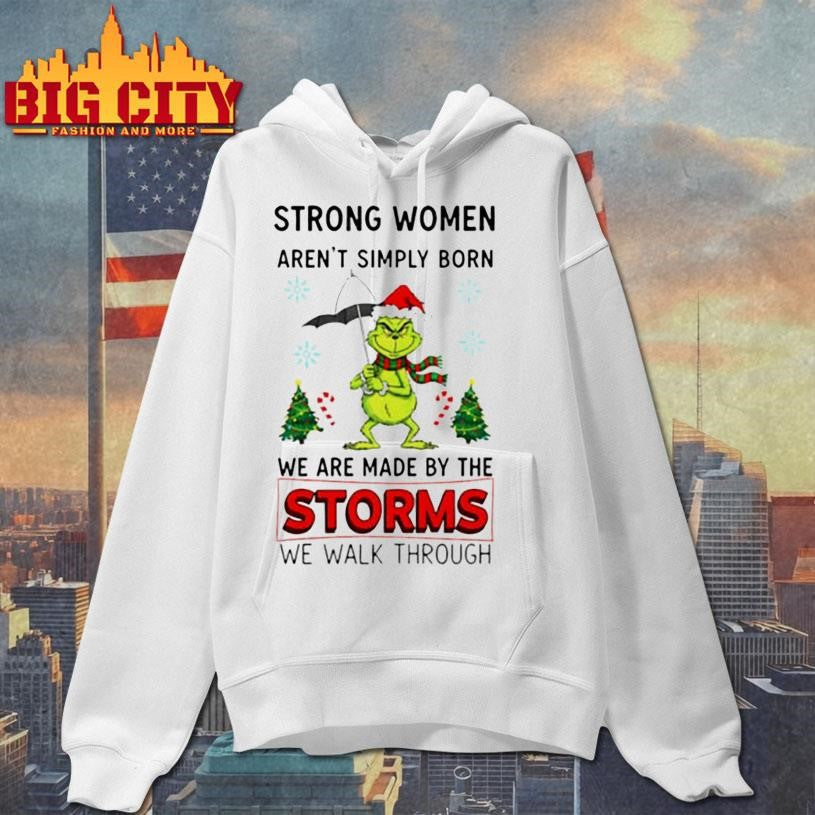 Grinch Santa hat strong women aren’t simply born we are made by the storms we walk through Merry Christmas shirt