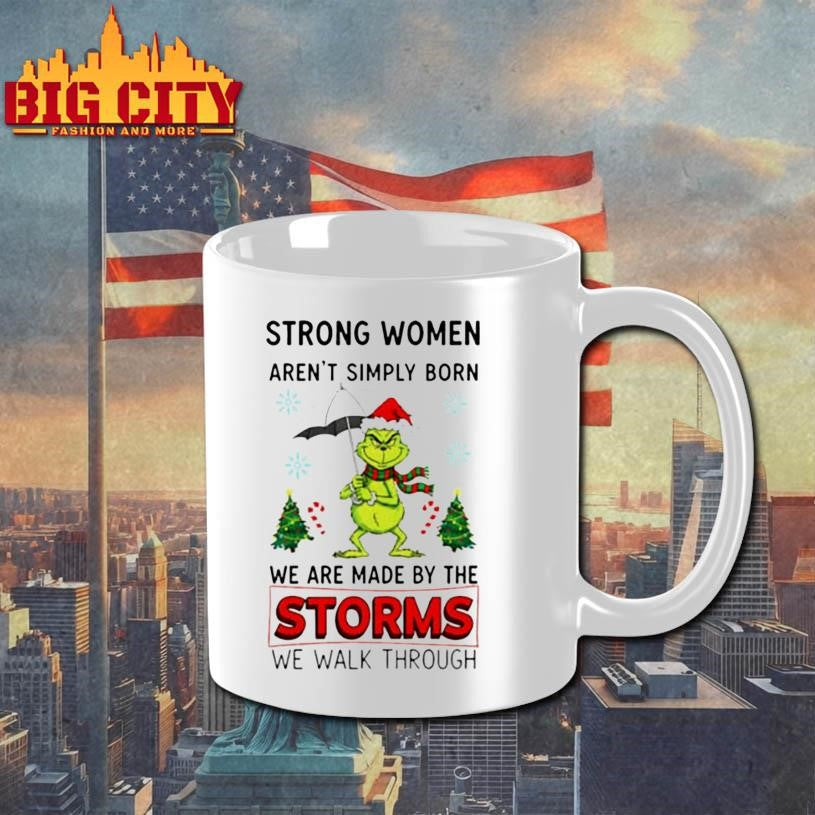 Grinch Santa hat strong women aren’t simply born we are made by the storms we walk through Merry Christmas shirt